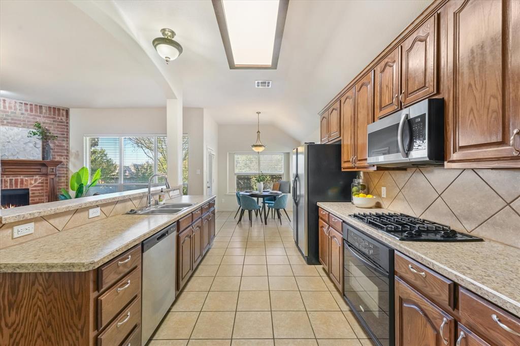 12811 Greenhaven Drive Frisco, TX 75035 - Photo 11 of 28 a kitchen with stainless steel appliances granite countertop a stove and a sink