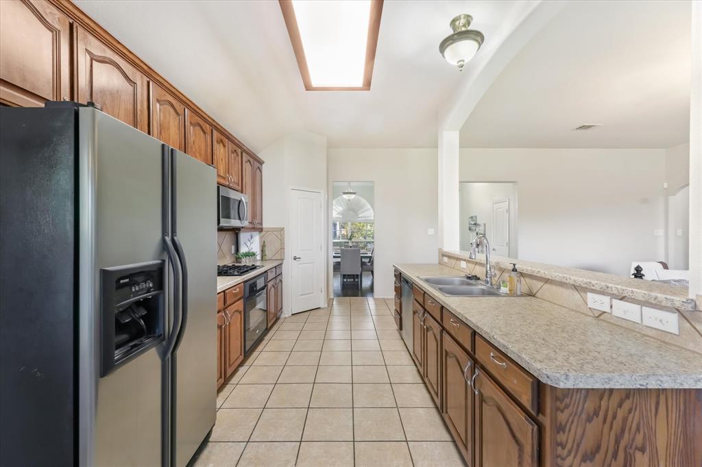 12811 Greenhaven Drive Frisco, TX 75035 - Photo 12 of 28 a large kitchen with a sink a counter top space and stainless steel appliances