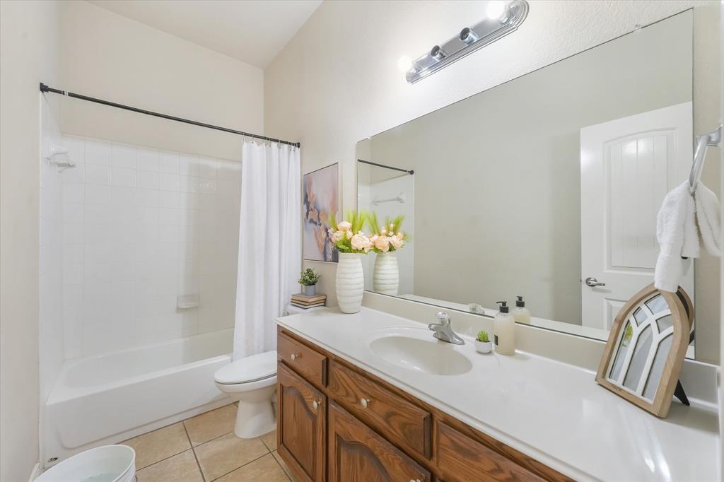 12811 Greenhaven Drive Frisco, TX 75035 - Photo 21 of 28 a bathroom with a granite countertop sink and a mirror