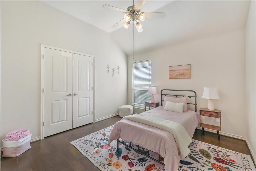 12811 Greenhaven Drive Frisco, TX 75035 - Photo 22 of 28 a bedroom with a bed and a chandelier