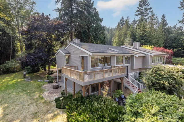 a aerial view of house with yard and trees around