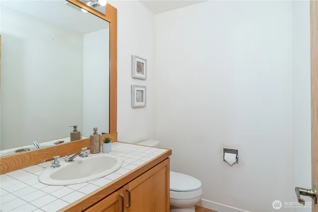 a bathroom with a sink vanity mirror and toilet