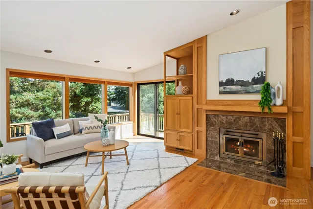 a living room with furniture a large window and a fireplace