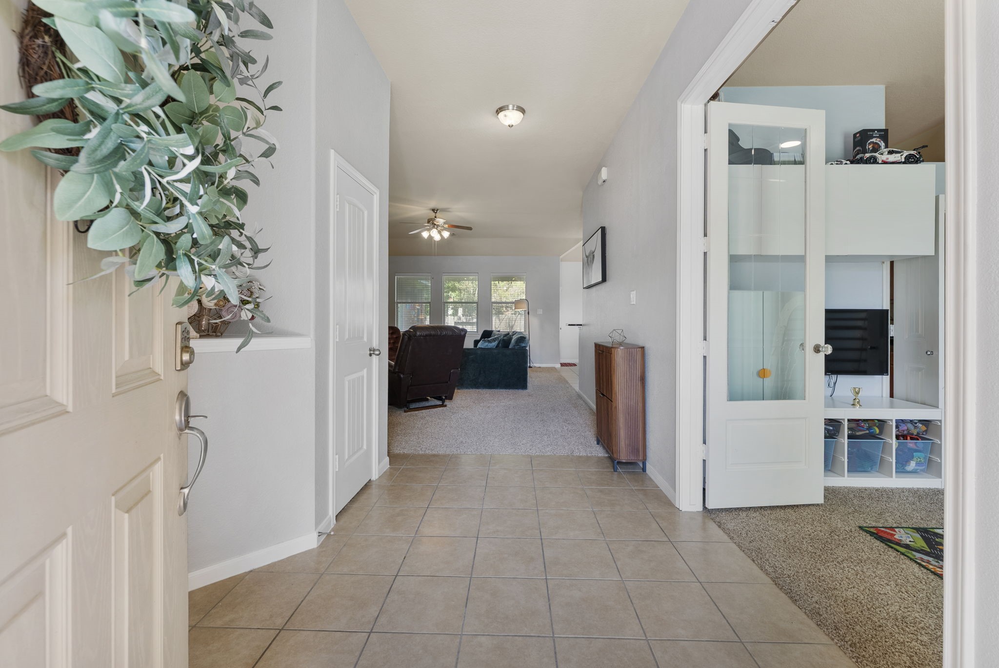174 Maple Grove Drive Conroe, TX 77384 - Photo 4 of 26 Step inside to open sightlines with the family room and kitchen ahead, while a dedicated study to the right offers the perfect private workspace.