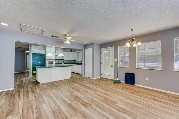 a large kitchen with kitchen island white cabinets and stainless steel appliances