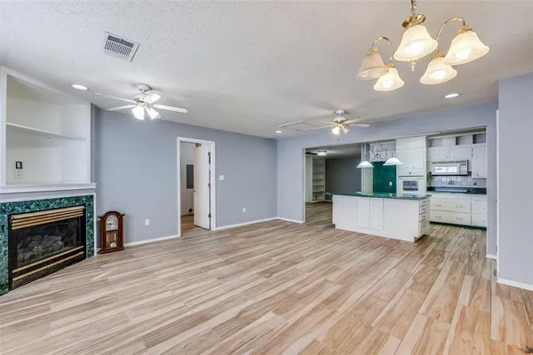 a kitchen with a sink chandelier and wooden floor