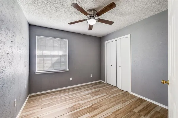 an empty room with a window and ceiling fan