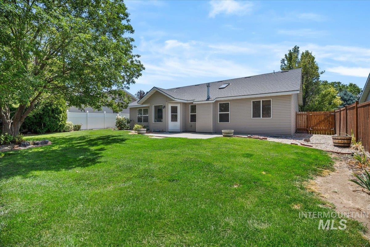 2032 Talus Loop Twin Falls, ID 83301 - Photo 41 of 43 Expansive backyard featuring a manicured lawn, established shade tree, and a concrete patio