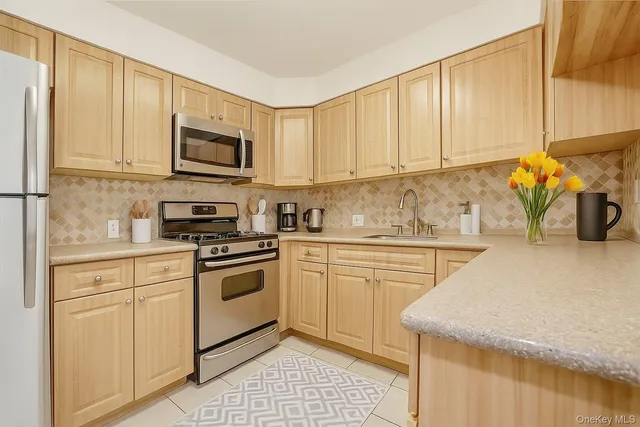 a kitchen with stainless steel appliances granite countertop a sink a stove and white cabinets