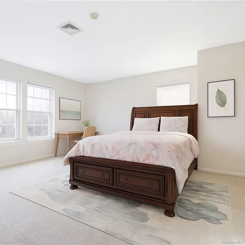 a spacious bedroom with a bed and large windows