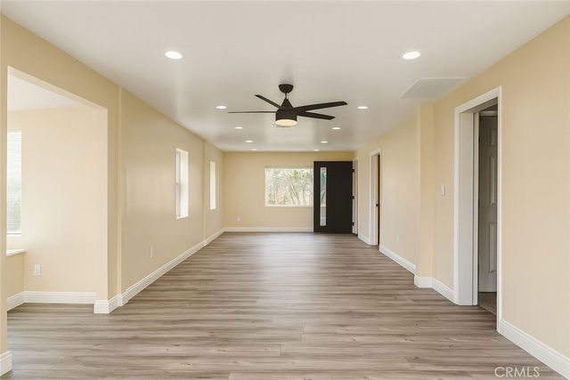 a view of an empty room with window and wooden floor