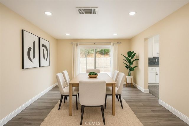 a view of a a dining room with furniture window and wooden floor