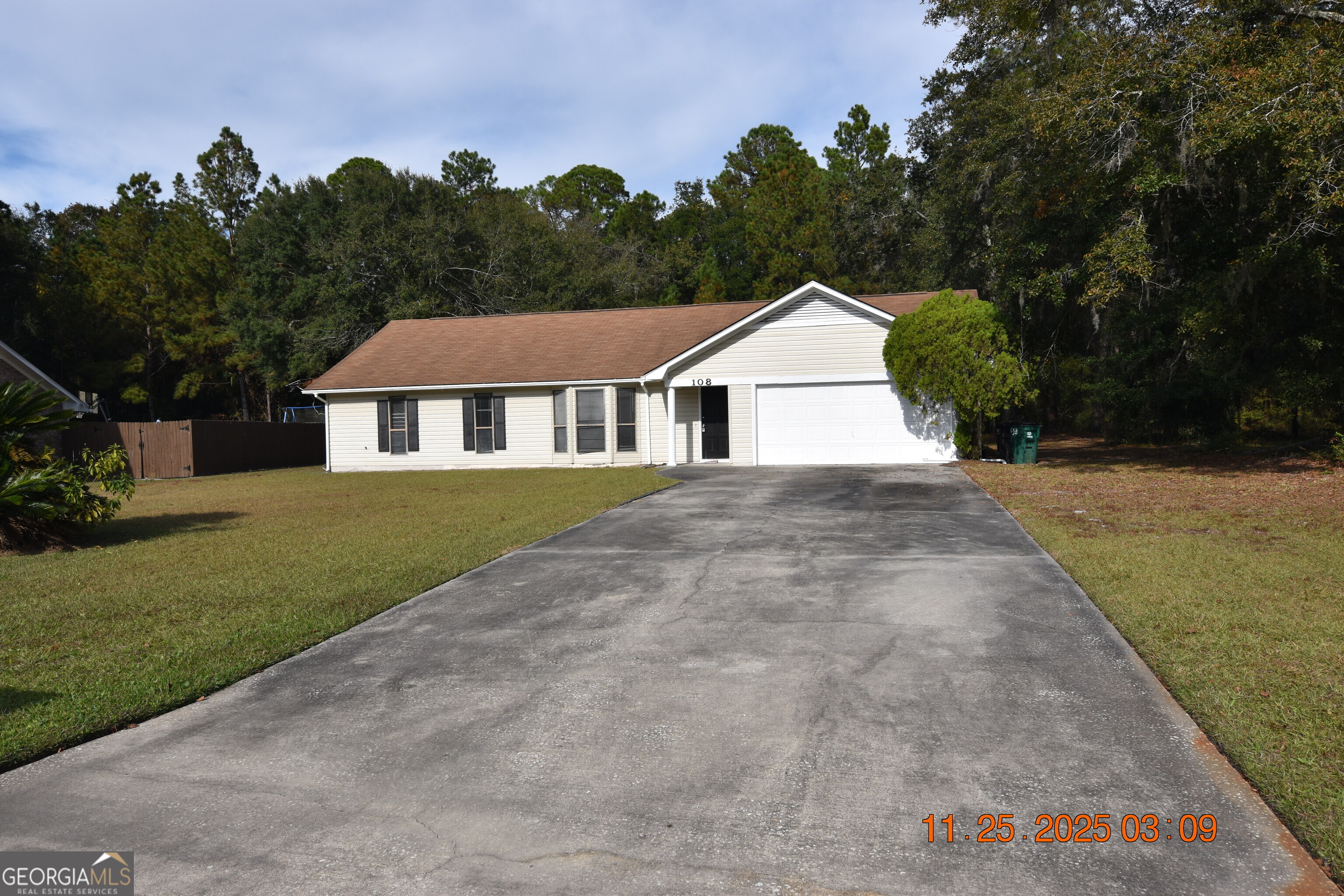 a view of a yard in front of a house with large trees
