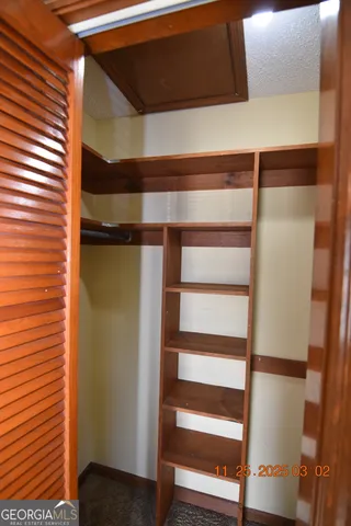 a view of walk in closet with empty racks