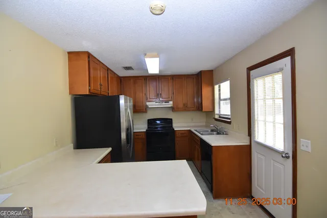 a kitchen with stainless steel appliances a refrigerator and a sink