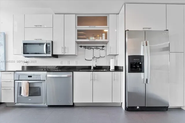 a kitchen with appliances a sink and cabinets