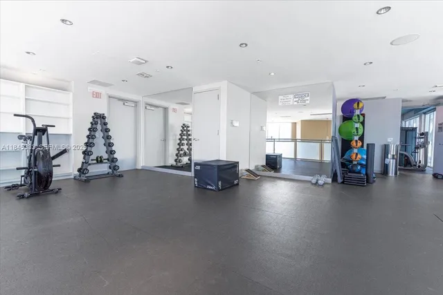 a living room with couches and kitchen view with wooden floor