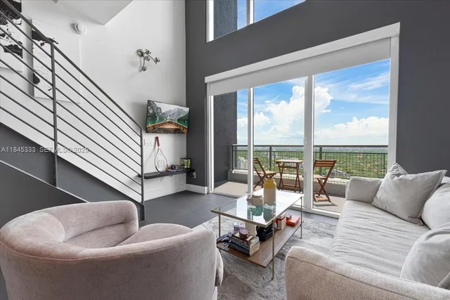 a living room with furniture and floor to ceiling windows