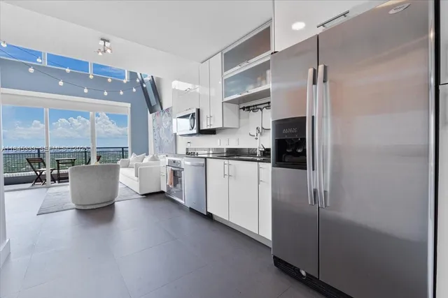 a kitchen with a refrigerator and white cabinets