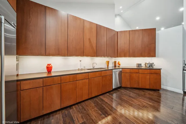 a kitchen with stainless steel appliances kitchen island granite countertop a stove a sink and a refrigerator