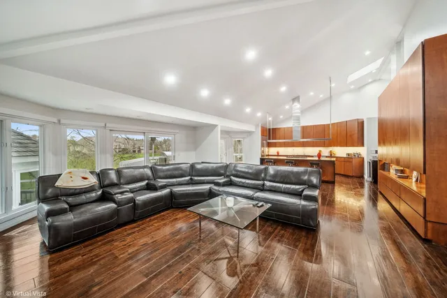 a large kitchen with stainless steel appliances a large counter top a stove and a wooden floors