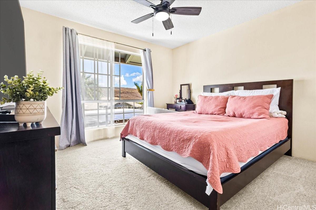 92-1019 Alaa Street, Unit 16203 Kapolei, HI 96707 - Photo 13 of 25 a bedroom with a bed and a window