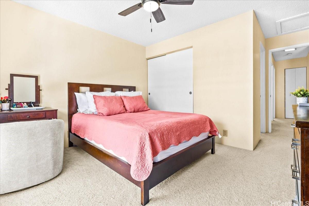 92-1019 Alaa Street, Unit 16203 Kapolei, HI 96707 - Photo 14 of 25 a spacious bedroom with a bed and a chandelier