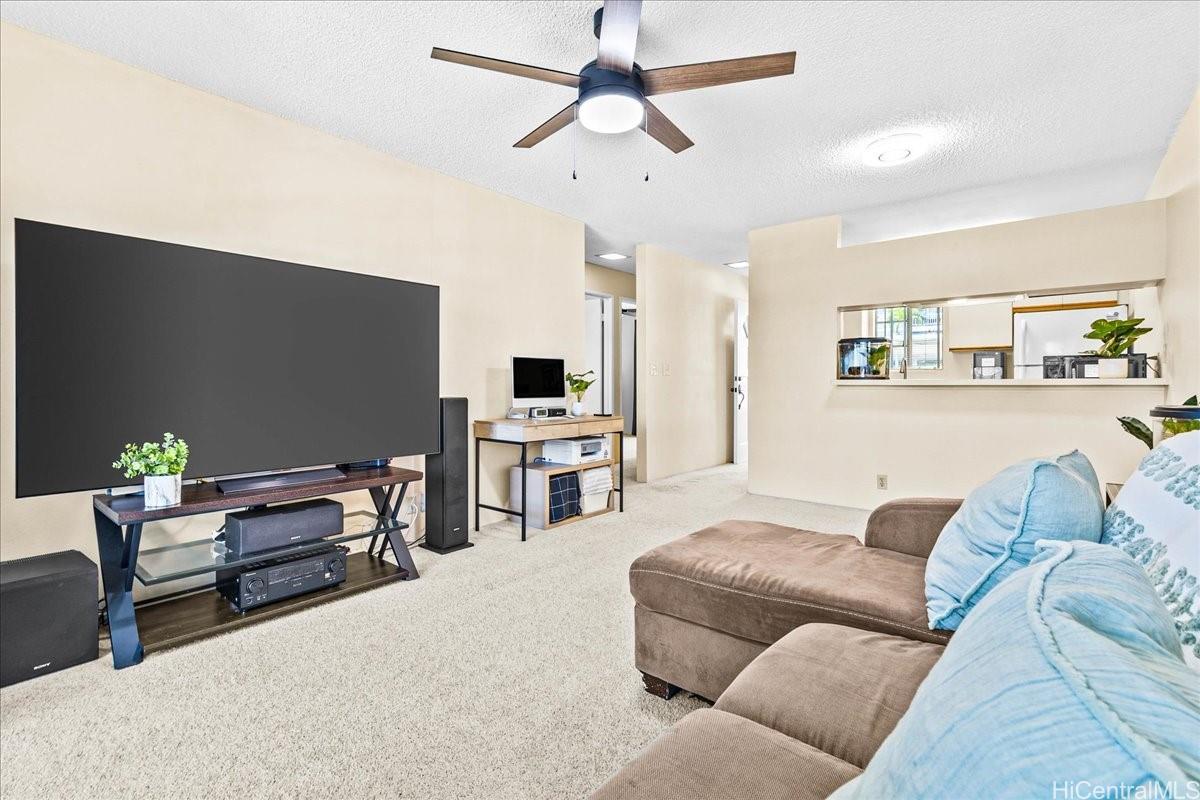 92-1019 Alaa Street, Unit 16203 Kapolei, HI 96707 - Photo 20 of 25 a living room with furniture and kitchen view