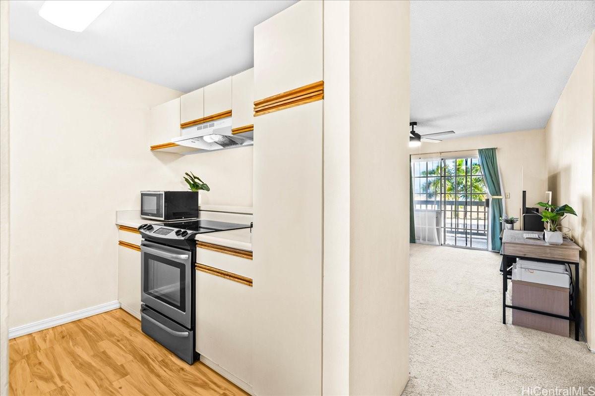 92-1019 Alaa Street, Unit 16203 Kapolei, HI 96707 - Photo 4 of 25 a kitchen with stainless steel appliances granite countertop a stove and a refrigerator