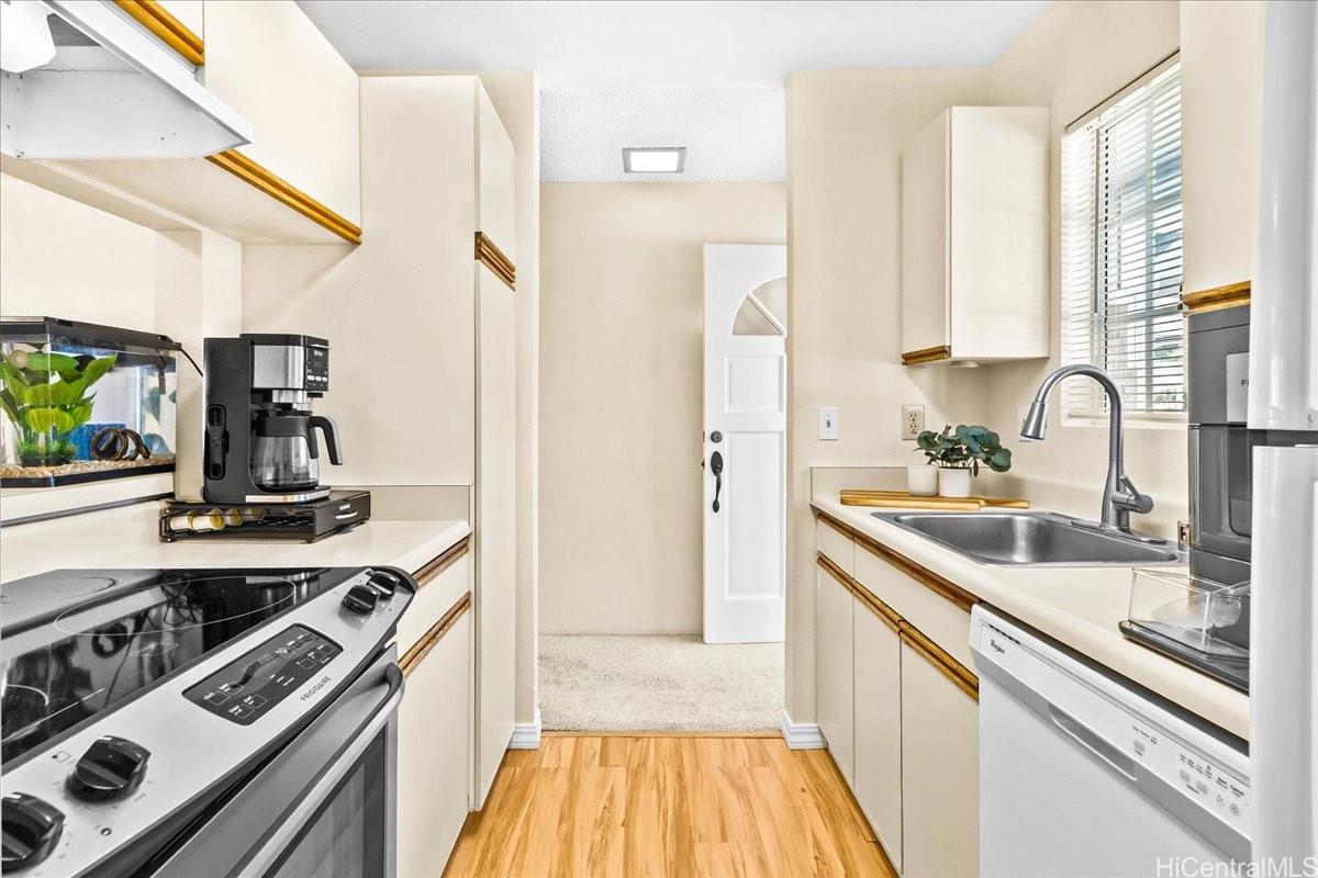 92-1019 Alaa Street, Unit 16203 Kapolei, HI 96707 - Photo 6 of 25 a kitchen with a sink stove and refrigerator