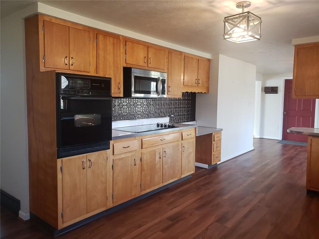 161 North Benbrook Road Butler, PA 16001 - Photo 6 of 25 a kitchen with stainless steel appliances granite countertop a refrigerator a stove top oven a sink and dishwasher with wooden floor