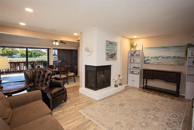 a living room with furniture a fireplace and a floor to ceiling window