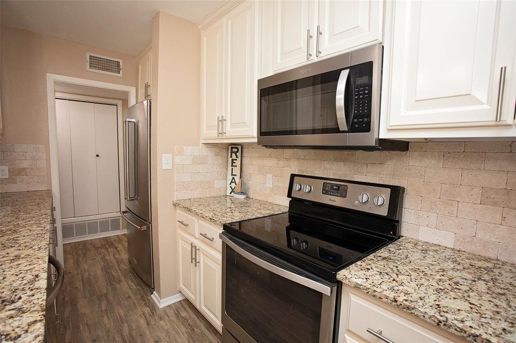 1361 Willow Beach Road, Unit A5 Graford, TX 76449 - Photo 6 of 17 a kitchen with stainless steel appliances granite countertop a stove microwave and sink
