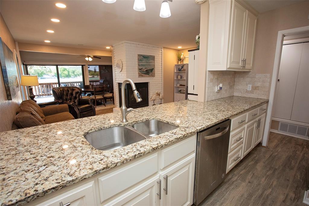 1361 Willow Beach Road, Unit A5 Graford, TX 76449 - Photo 7 of 17 a kitchen with granite countertop a sink a counter top space and stainless steel appliances