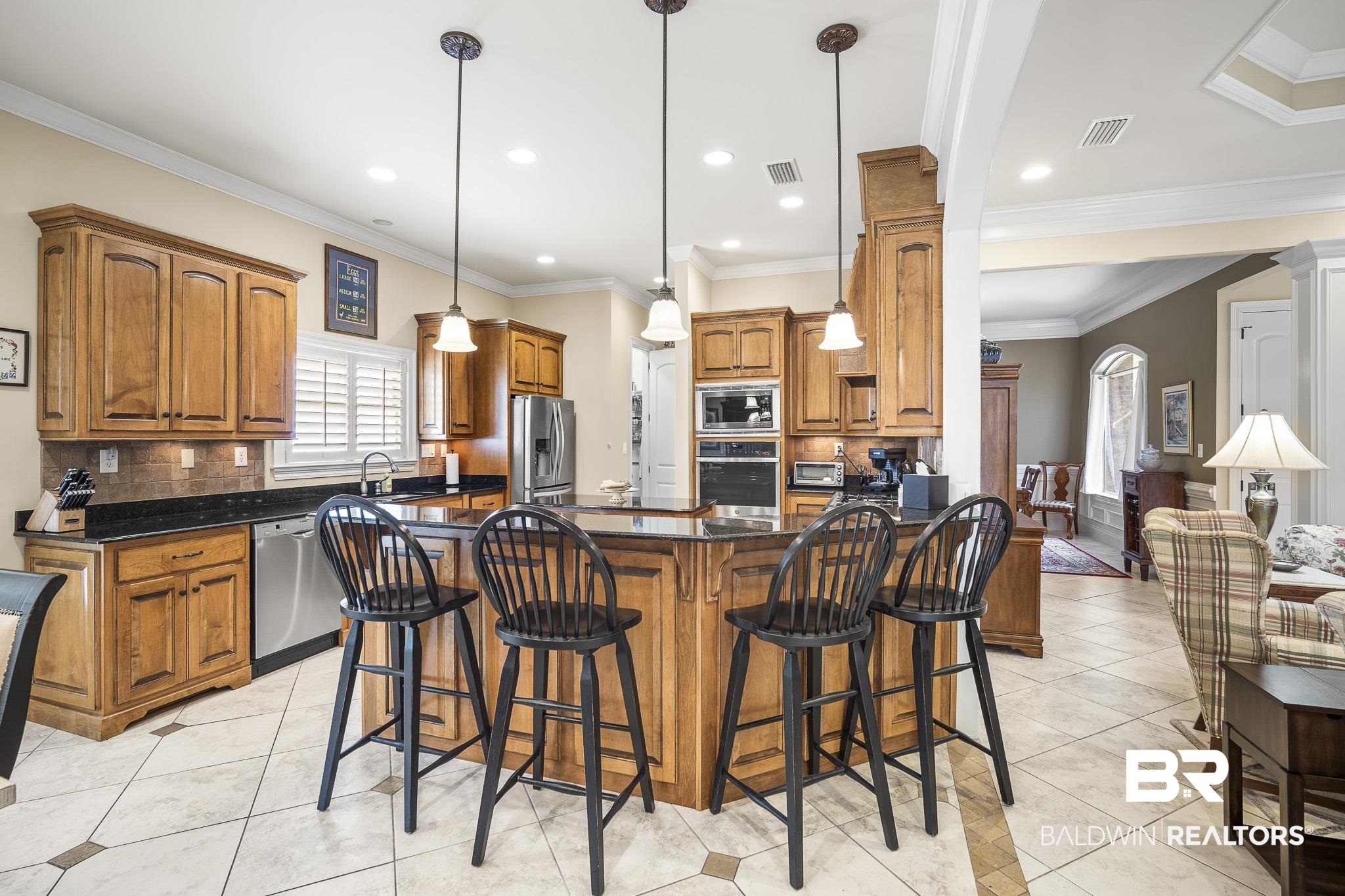 7090 Carson Lane Daphne, AL 36527 - Photo 9 of 37 Kitchen with ornamental molding, decorative light fixtures, light tile patterned floors, and stainless steel appliances
