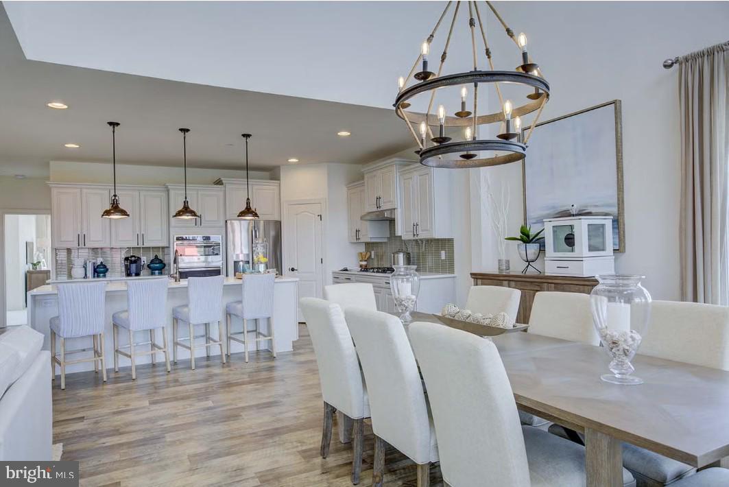 401 Bering Road Ocean City, MD 21842 - Photo 29 of 74 a view of a dining room with furniture a chandelier and wooden floor