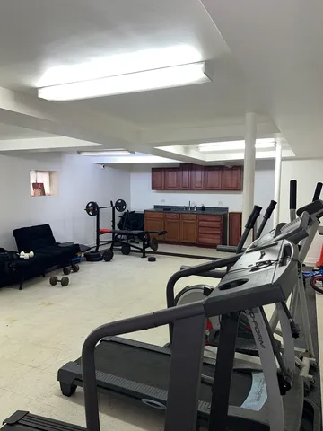 a room with gym equipment and a wooden floor