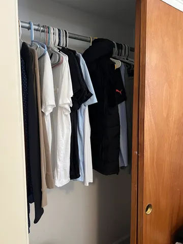 a view of walk in closet with clothes and shoes