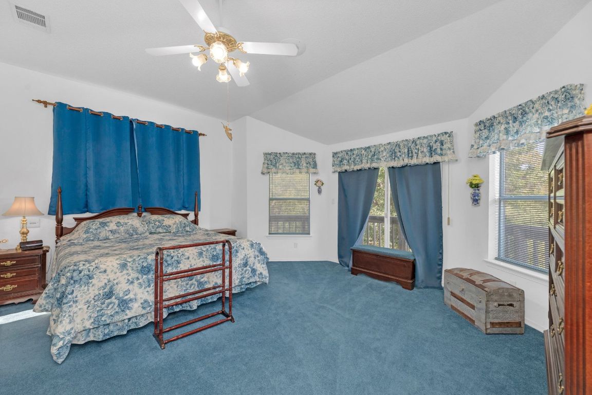 2105 Sam Bass Road Round Rock, TX 78681 - Photo 19 of 40 a spacious bedroom with a bed and a chandelier