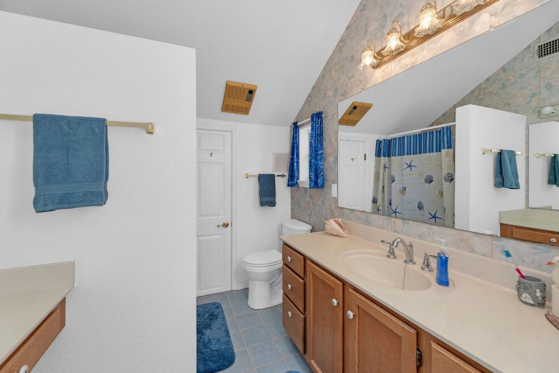 2105 Sam Bass Road Round Rock, TX 78681 - Photo 22 of 40 a bathroom with a sink a toilet and a shower