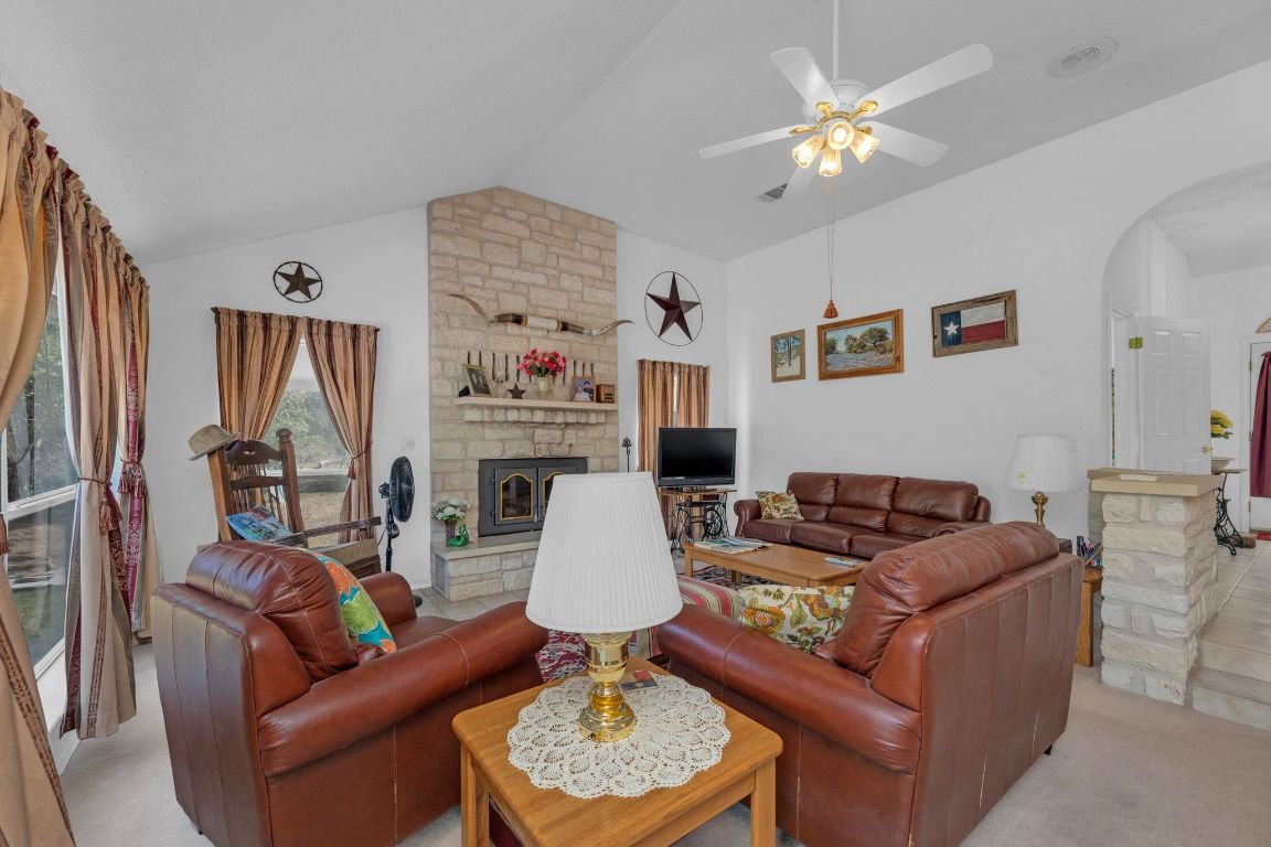 2105 Sam Bass Road Round Rock, TX 78681 - Photo 10 of 40 a living room with furniture a fireplace and a chandelier