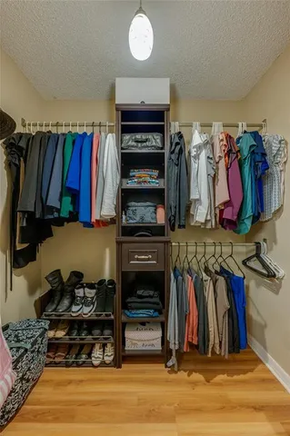 a view of walk in closet with clothes and shoes