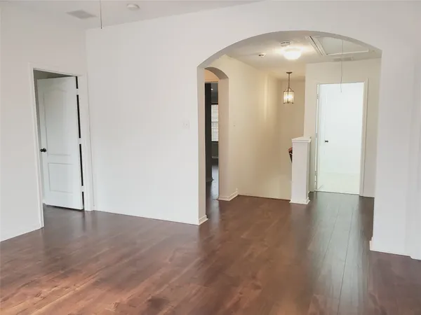 an empty room with wooden floor and mirror