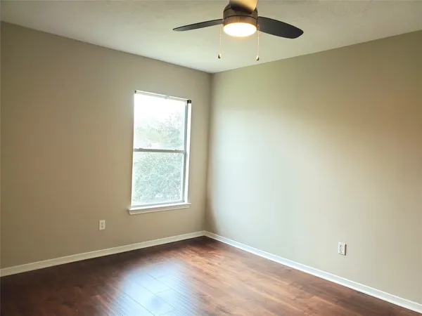 an empty room with a window and wooden floor