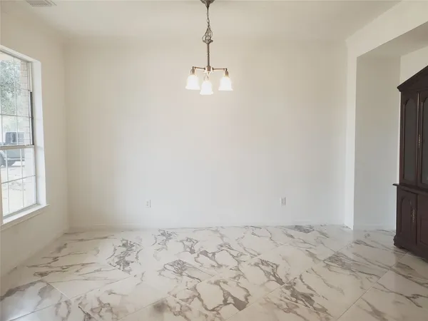 a view of a room with a bed and wooden floor