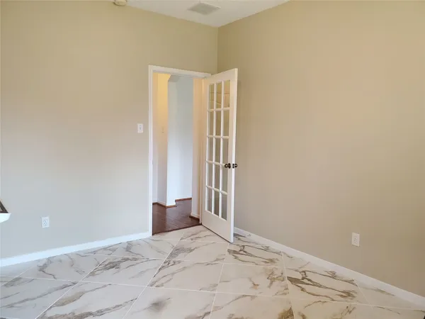 a view of a hallway with wooden floor and a bathroom