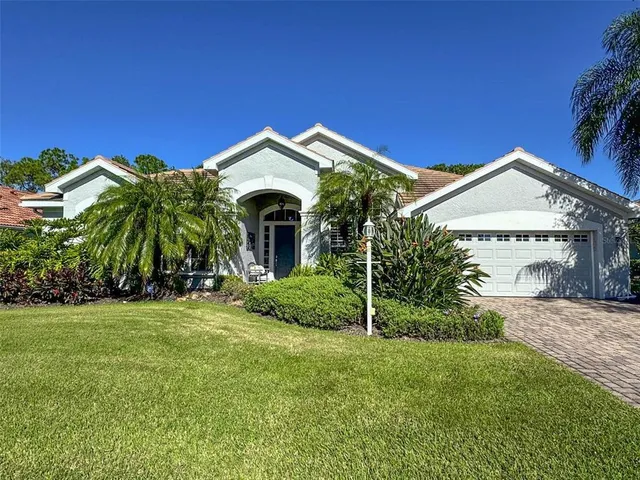 a view of a house with a small yard and a palm tree