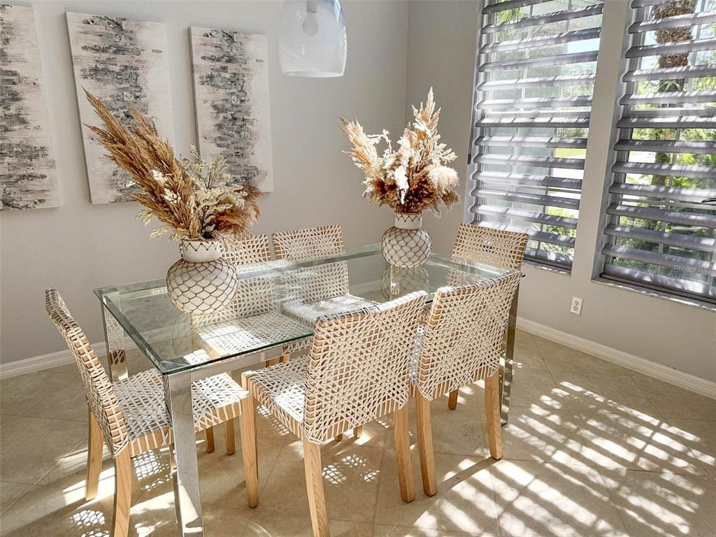 8204 Waterview Boulevard Lakewood Ranch, FL 34202 - Photo 11 of 77 a dining room with furniture a large window and potted plants