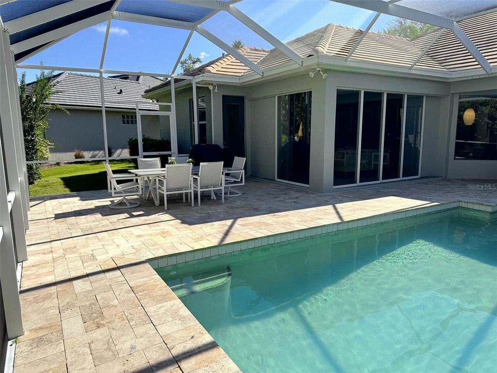 8204 Waterview Boulevard Lakewood Ranch, FL 34202 - Photo 42 of 77 a view of a patio with table and chairs under an umbrella