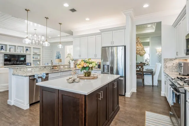 a kitchen with kitchen island granite countertop a sink appliances and cabinets